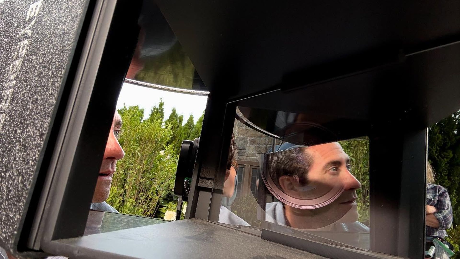 Jake Gyllenhaal patrzy w sprzęt z lustrami i soczewkami, jego twarz odbija się w optycznych powierzchniach