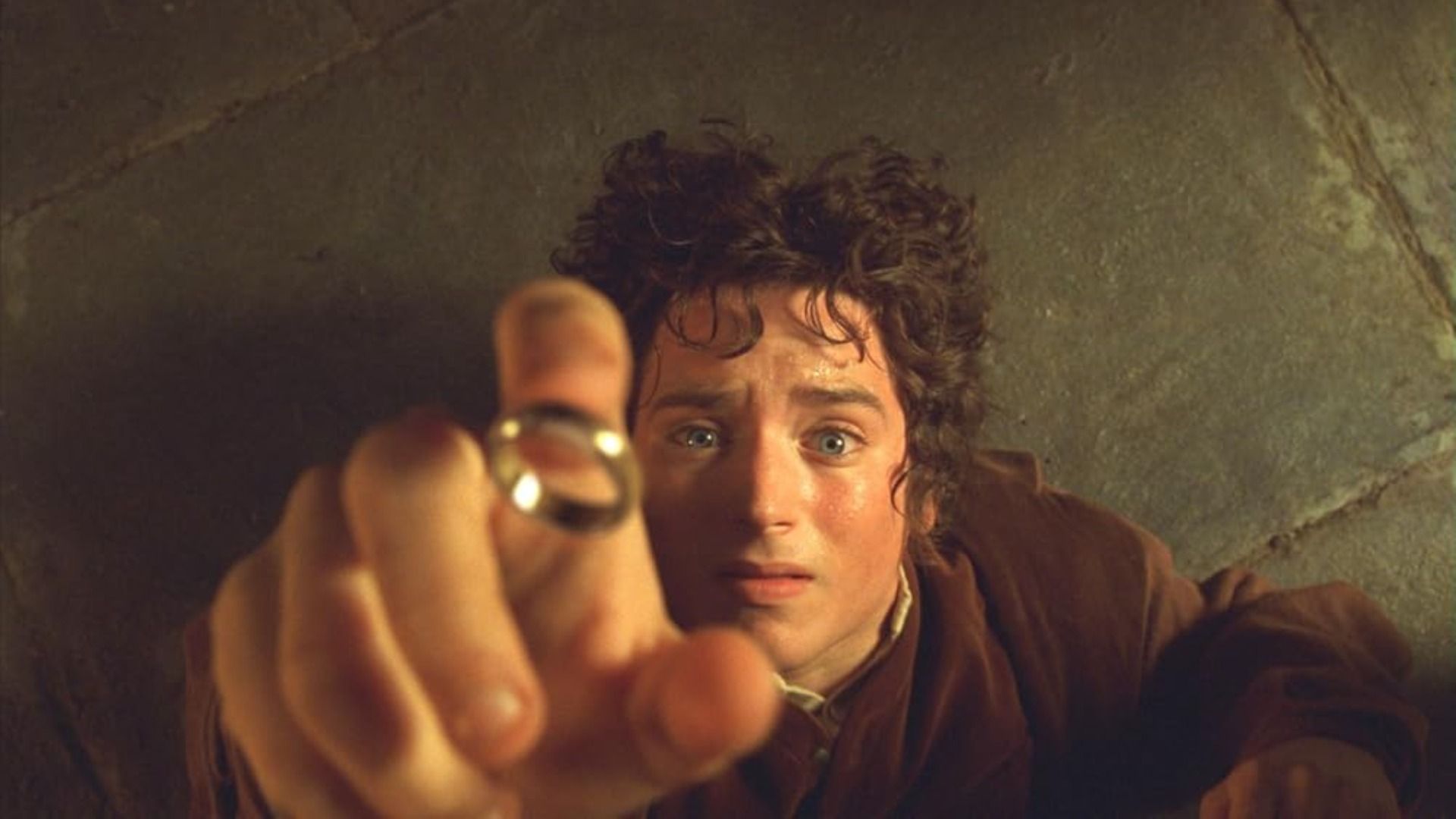 Aktor Elijah Wood sięga po złoty pierścień w przerażeniu, upadając na podłogę