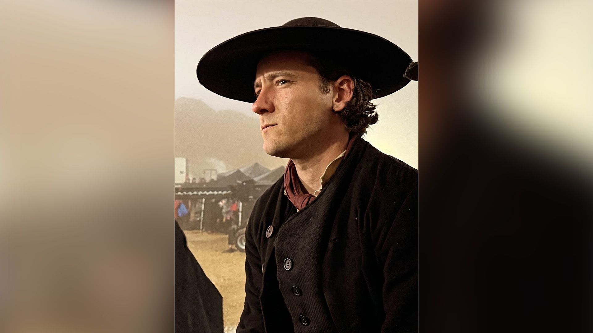 Lewis Pullman w czarnej wełnianej kurtce i czarnym kapeluszu z szerokim rondem