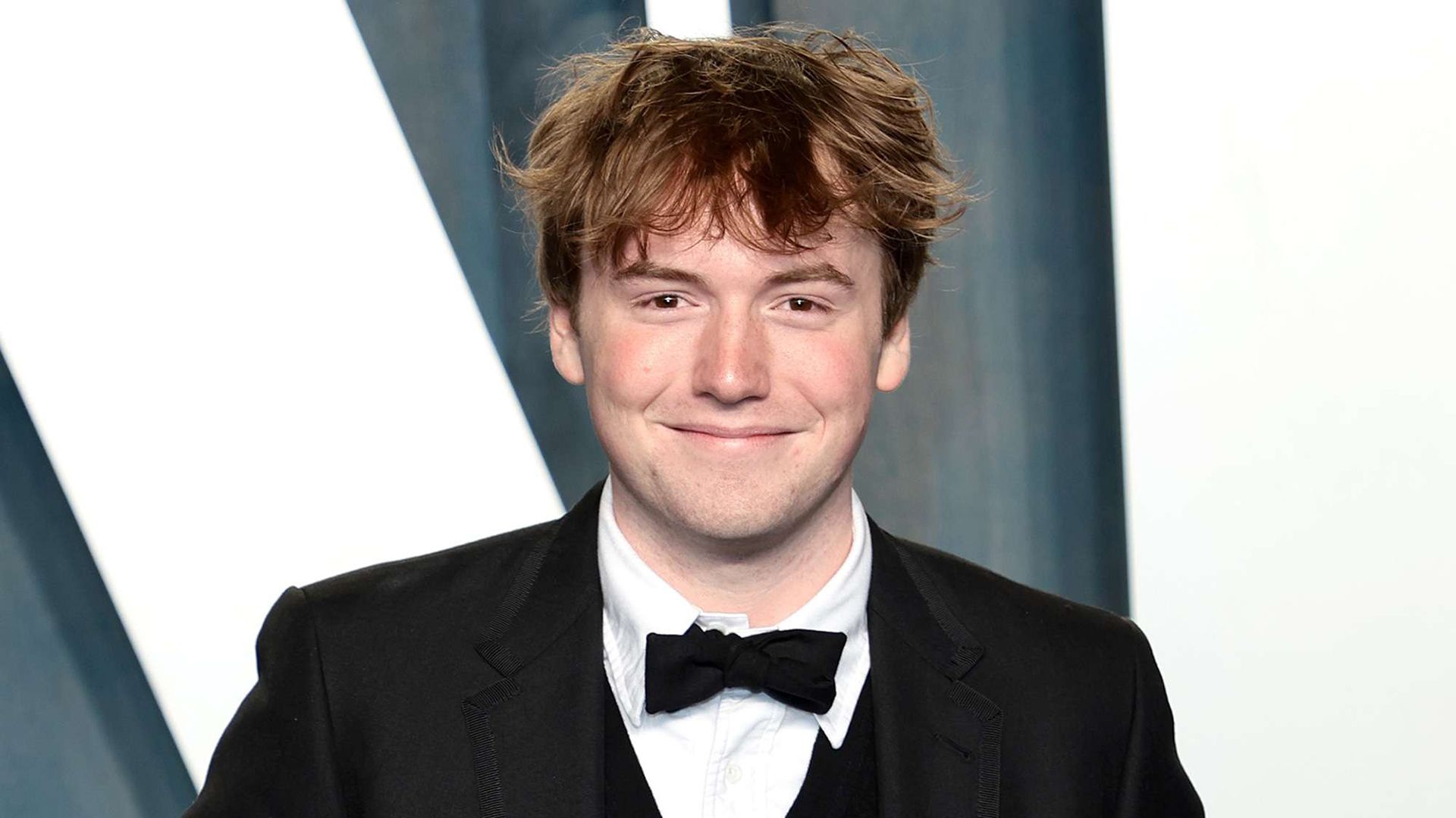 Aktor Cooper Hoffman w smokingu i muszce