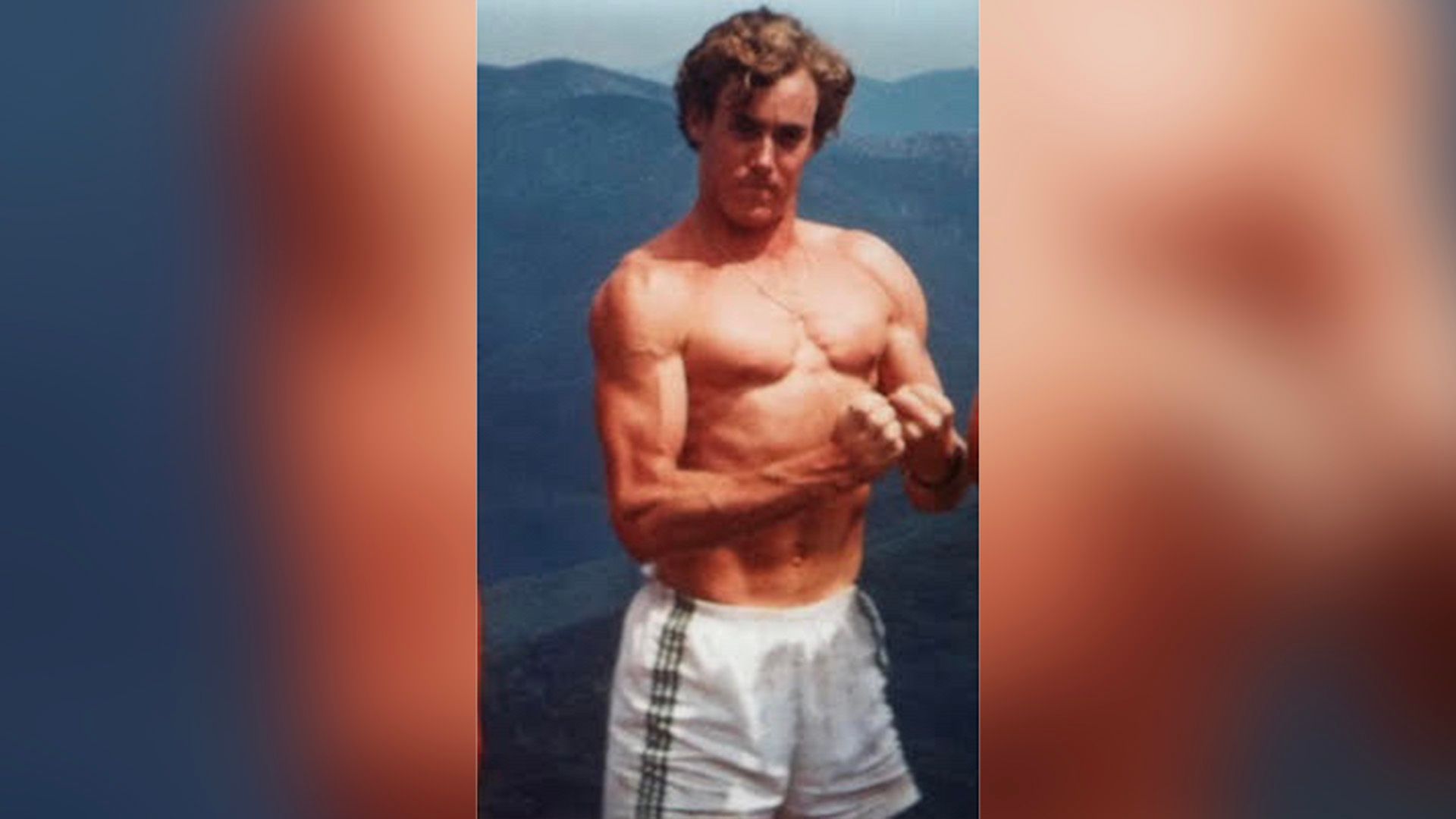 Młody John C. McGinley w szortach prezentujący swoje mięśnie