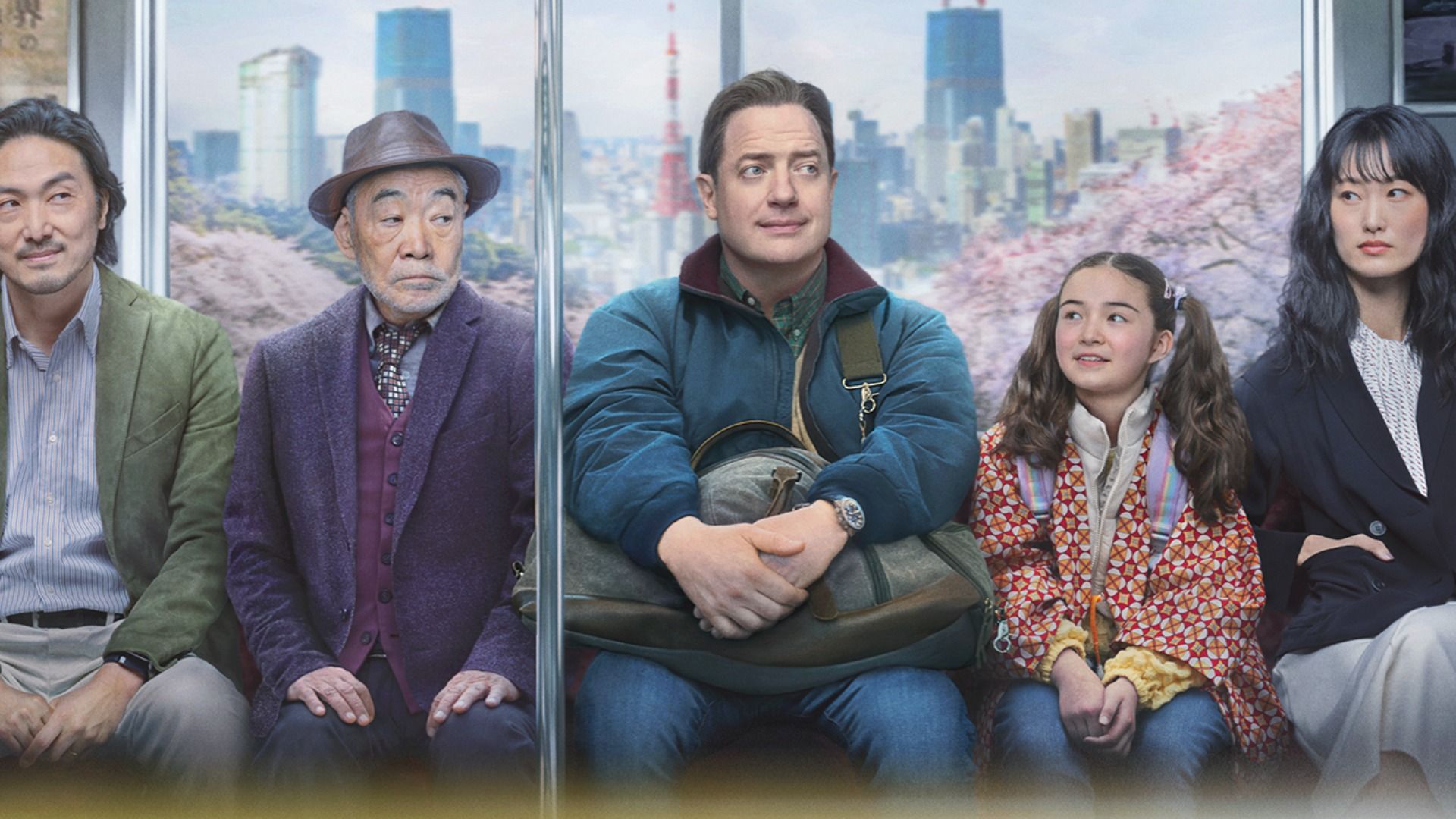 Aktor Brendan Fraser w niebieskiej kurtce jedzie metrem w otoczeniu ludzi